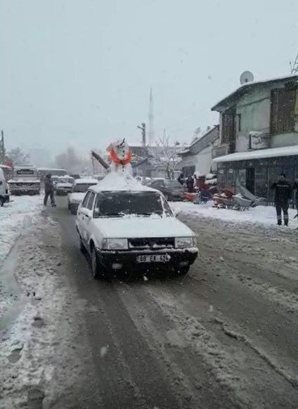 Otomobilinin üzerine kardan adam yapıp trafiğe çıktı