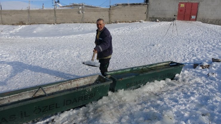 Sivaslı çoban, koyunların su içmesi için donan yalağın buzunu kürekle kırdı