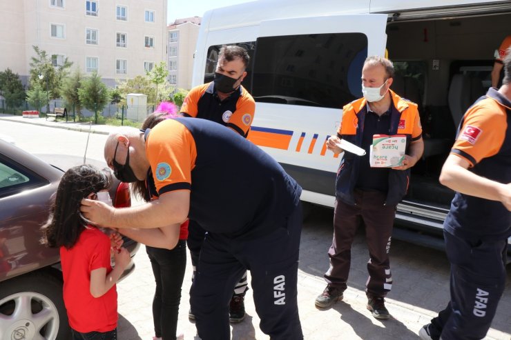 Sokaktaki çocuklar şekerleri verilip maskeleri takıldıktan sonra evlerine gönderildi