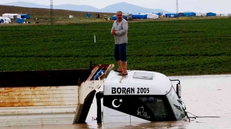 Sel sularına gömülen kamyonun üzerinde mahsur kaldılar