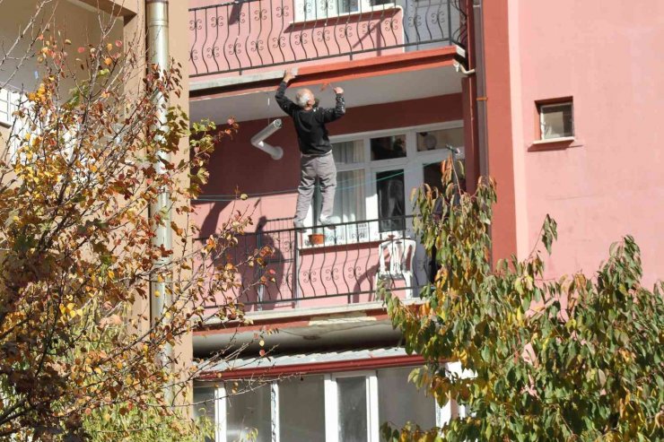 Çatıda yatarak sıva yapan usta bu kez de balkon demirine çıkıp boya yaptı