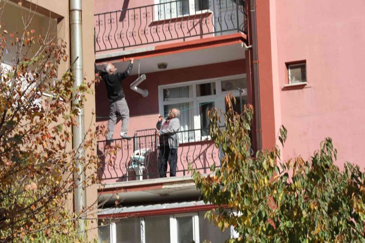 Çatıda yatarak sıva yapan usta bu kez de balkon demirine çıkıp boya yaptı